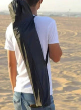 Folded portable camping chair with carry strap, dark fabric
