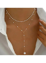 Layered pearl drop necklace with multiple pearl strands and hanging pearl at center