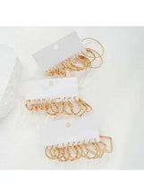 Gold-tone hoop and cuff earrings set with layered hoop shapes on cards