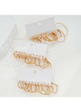 Gold-tone cuff and hoop earrings set with three styles on white display cards