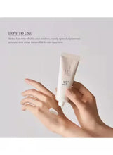 Hands applying white face sunscreen cream from a tube onto skin.