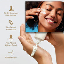 Sunscreen on a smiling woman with cream on her face; tube held in hand.