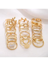 Gold finger ring set featuring heart, leaf, pearl, and chain ring designs