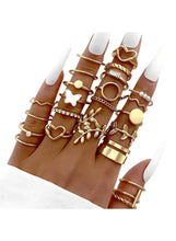 Gold multi-style finger ring set with mixed hearts, pearls, and band rings