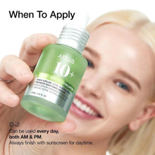 Hand holding green Anua 10+ serum bottle while a person smiles