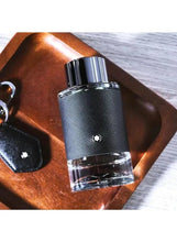 Men’s eau de parfum bottle with black textured body and clear liquid base on wood