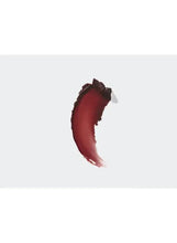 Lipstick color swatch in deep maroon, curved smear on a light background