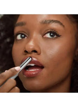 Lipstick being applied with a silver bullet over full lips