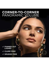 Model holding mascara wand with corner-to-corner lash look
