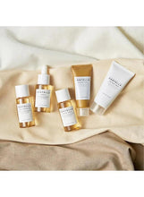 Centella travel kit skincare bottles and tubes on beige fabric cloth
