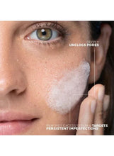 Facial skin close-up with fingertip applying purifying gel around cheek