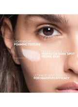 Close-up of a woman’s face with foaming skincare texture over the cheek