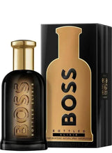 Men’s fragrance bottle and box, black glass with gold cap and Boss Bottled Elixir text