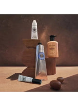 L'OCCITANE cream tubes on a shelf, including a hand cream tube
