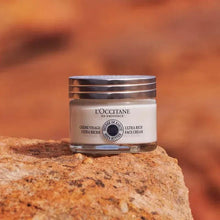 Ultra-rich face cream jar with silver lid on textured stone.
