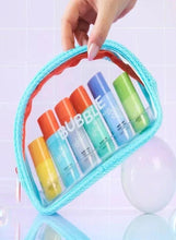 Turquoise zip pouch holding miniature skincare bottles with orange and green caps