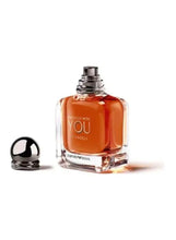 Eau de parfum bottle, dark amber liquid in clear glass, Stronger With You Intense