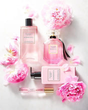 Bombshell fragrance mist bottle with black cap and pink label, plus smaller spray bottle