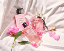 Bombshell fragrance mist bottles with black caps and pink clear glass, ribbon accents
