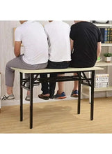 Light wood foldable desk table with black metal legs, being used