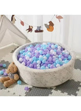 Mixed-color baby chew pool balls and star pieces in a white basin