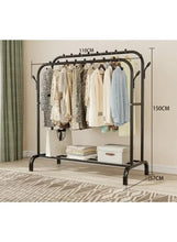 Black metal clothes rack with double rail, side hooks, and storage shelf