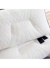 Quilted latex pillow corner seam detail with dark label, white cover.