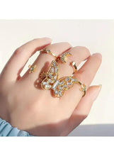 Gold-plated adjustable rings on hand, butterfly crystal cluster and moon charm