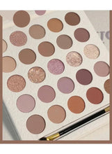Close-up of cream eyeshadow palette showing matte and shimmer pans