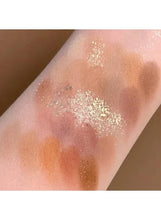 Swatch on skin: glittery cream-gold and warm brown eyeshadow in soft smudges