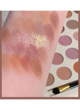 Close-up swatch: glittery gold and warm brown eyeshadow on the back of a hand