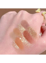 Hand swatch of multiple shimmer lines and dots in gold and warm brown