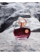 Purple perfume bottle with rose-gold cap and ring, on light stone