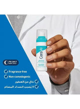 Teal-and-white skincare bottle held in hand, pump top visible