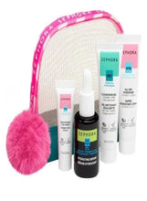 Skincare gift set with beige pouch, pink trim, purple pom-pom, and four full-size bottles