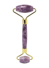 Purple quartz facial roller with gold-tone metal handles and center roller