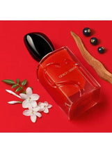 Red eau de parfum bottle with black cap and Giorgio Armani label