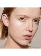 Sheer glow enhancer sheen on face, light pink finish