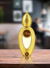 Gold perfume bottle standing upright, faceted oval body and decorative cap