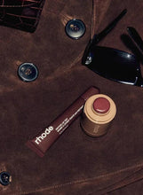Lip tint duo on fabric: dark tube applicator and bronze balm pot