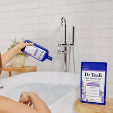 Dr Teal's lavender Epsom bath salt pouch being poured into a bathtub