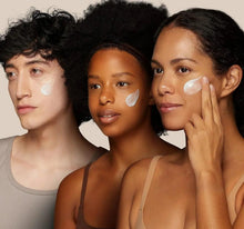 Three models with cream dots on their faces, showing soothing application