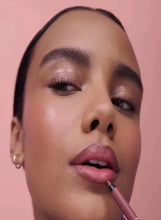 Pink lip liner pencil applying to lips with a defined edge.