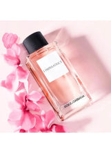 Pink glass Eau de Toilette bottle with black ribbed cap, label visible; with pink flowers