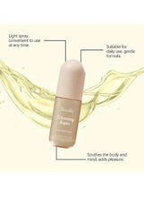 Hair perfume bottle with flowing liquid graphic, beige bottle and gold cap.