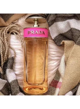 Eau de parfum bottle with PRADA label, amber liquid, clear glass cylinder