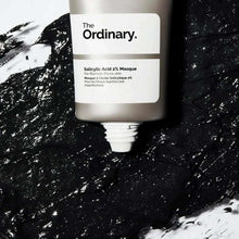 Salicylic acid 2% masque tube with nozzle dispensing dark mask on surface.