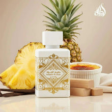 White perfume bottle with gold label on a table with pineapple and wooden boxes