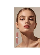 Lip oil applicator in clear tube beside model wearing nude pink matte lip color