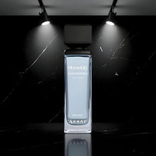 Perfume bottle with black cap, clear rectangular glass, ASSAF branding on front.